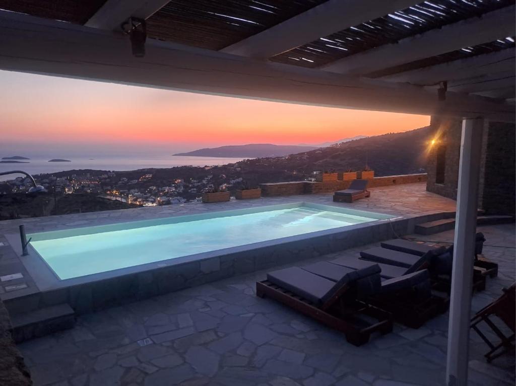 a swimming pool with a sunset in the background at "Aloe On the Rock" by Explore Andros in Batsi