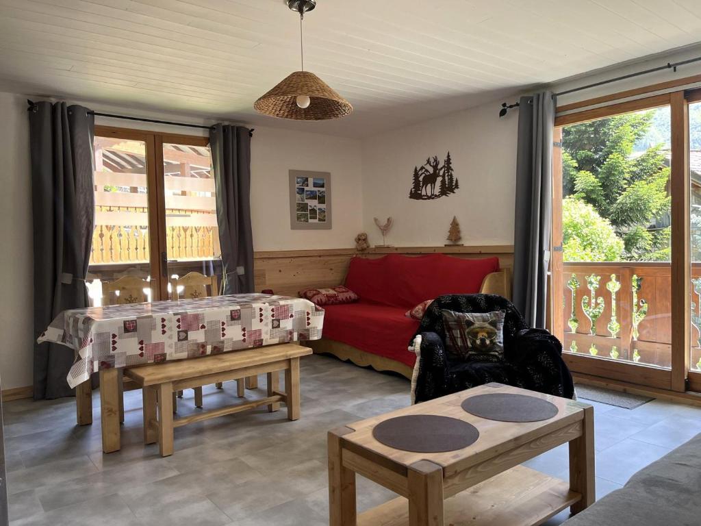 un salon avec un canapé rouge et une table dans l'établissement Charmant 2 pièces ensoleillé avec balcon, près des pistes et centre, parking inclus - FR-1-464-199, à Pralognan-la-Vanoise