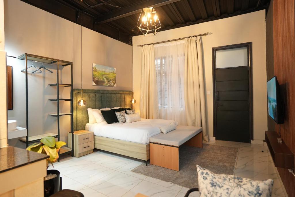 a bedroom with a bed and a desk and a television at The Suites Fourways in Nairobi
