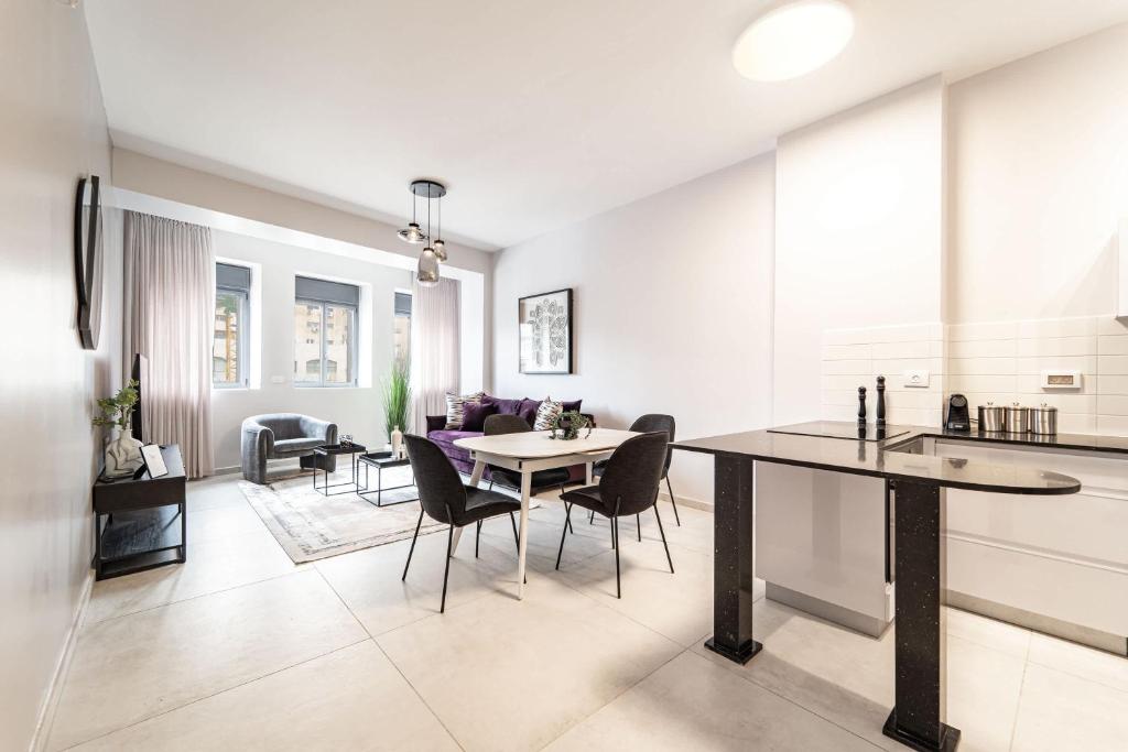 Una cocina y una sala de estar con mesa y sillas. en Dreamy 1Bdr Sanctuary In The Heart Of Jerusalem, en Jerusalén