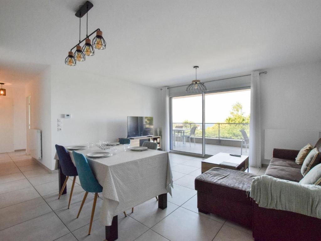 un salon avec une table et un canapé dans l'établissement Appartement neuf moderne avec balcon et garage à Évian - FR-1-498-103, à Évian-les-Bains
