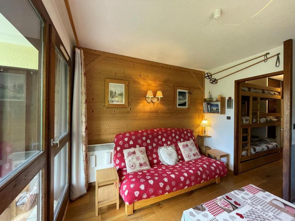 - un salon avec un canapé rouge dans l'établissement Studio cosy rez de chaussée 4 pers. près des pistes, équipé avec terrasse et parking. - FR-1-733-84, à Crest-Voland
