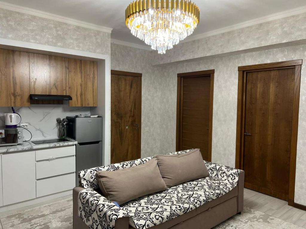 a living room with a couch and a chandelier at Апартамент,Новел отель,село Корумду in Korumdy