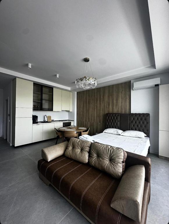 a bedroom with a bed and a couch and a kitchen at Axxis Luxury Studio in Mamaia