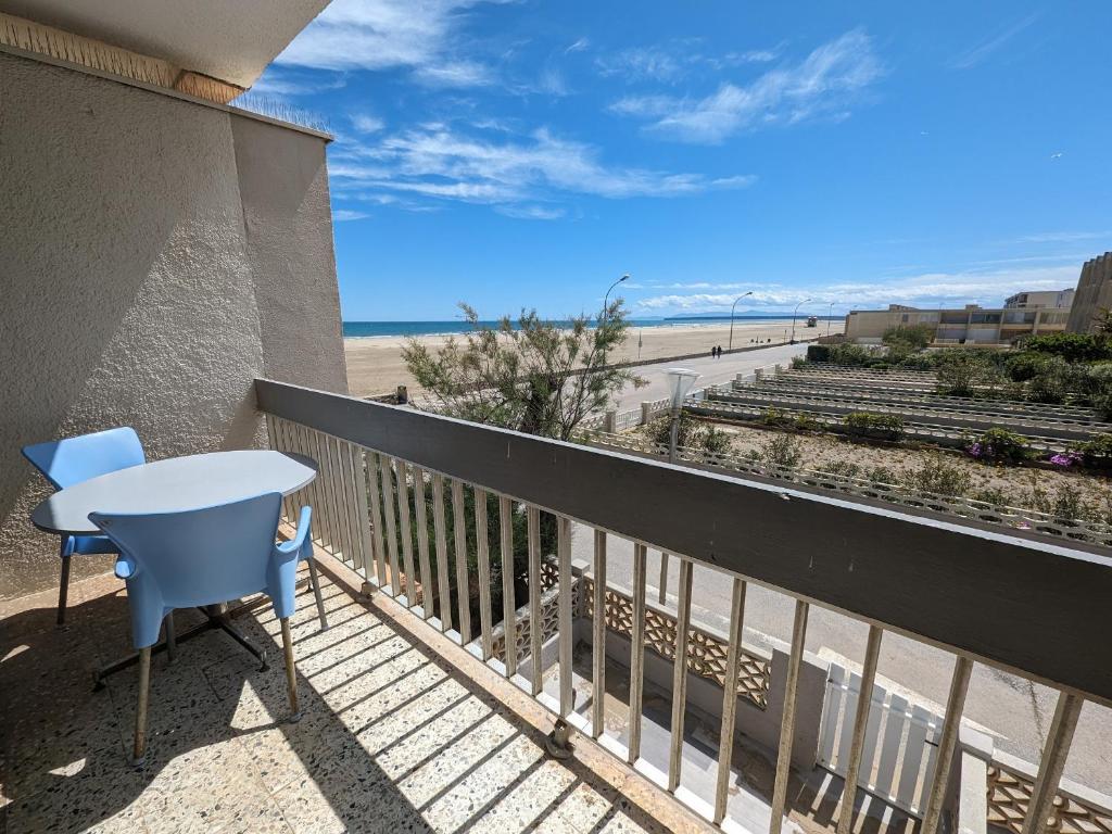 - un balcon avec une table et des chaises et la plage dans l'établissement T2 Moderne Port-la-Nouvelle - 4/5p - Parking - Front de Mer - FR-1-797-41, à Port-la-Nouvelle