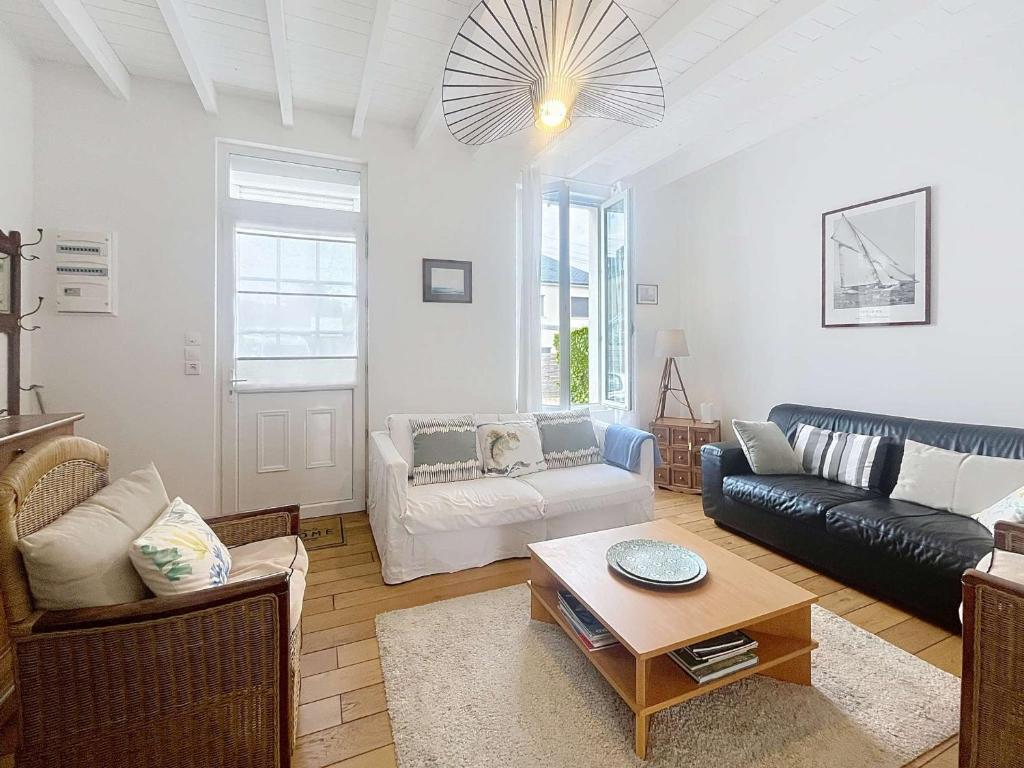 a living room with a couch and a table at Villa au Calme avec Jardin, Proche Plage et Commerces, Wifi et Équipements Complets - FR-1-361-117 in Jullouville-les-Pins
