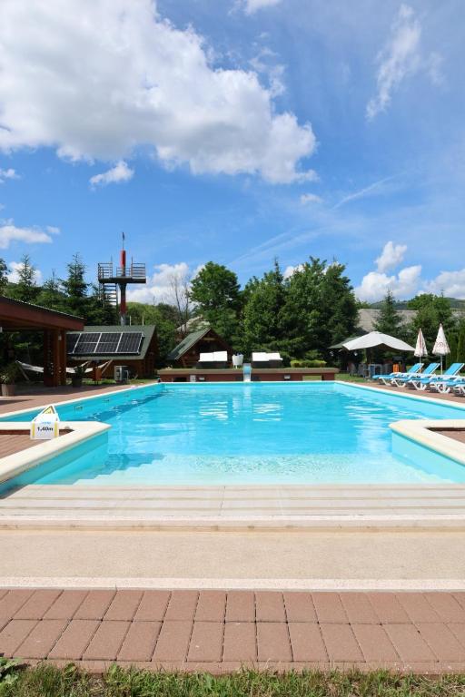 a large swimming pool with blue water at Cazare la Munte cu Piscină in Bistra