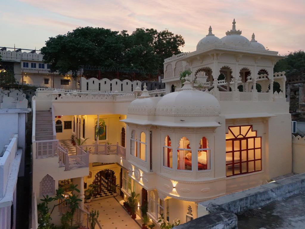 una vista aerea di una villa bianca con un tramonto di SaffronStays Rang Havelii - Luxurious Premium Rajasthani art-themed stay with City Palace views a Udaipur