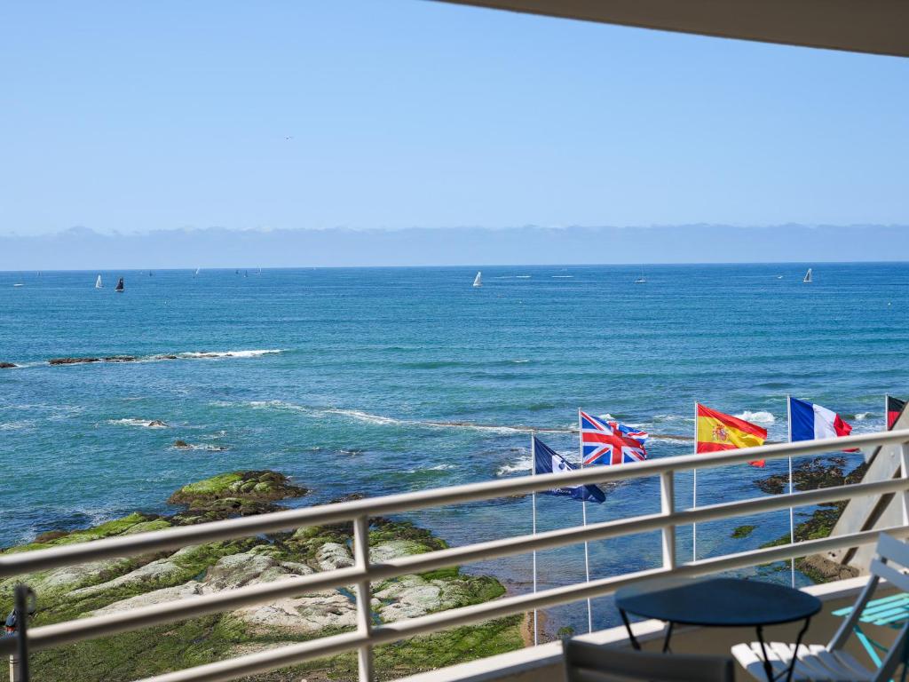 - un balcon avec drapeaux offrant une vue sur l'océan dans l'établissement Appartement Face Mer - 2 Chambres, Terrasse, Garage, Wi-Fi - FR-1-197-603, à Les Sables-dʼOlonne