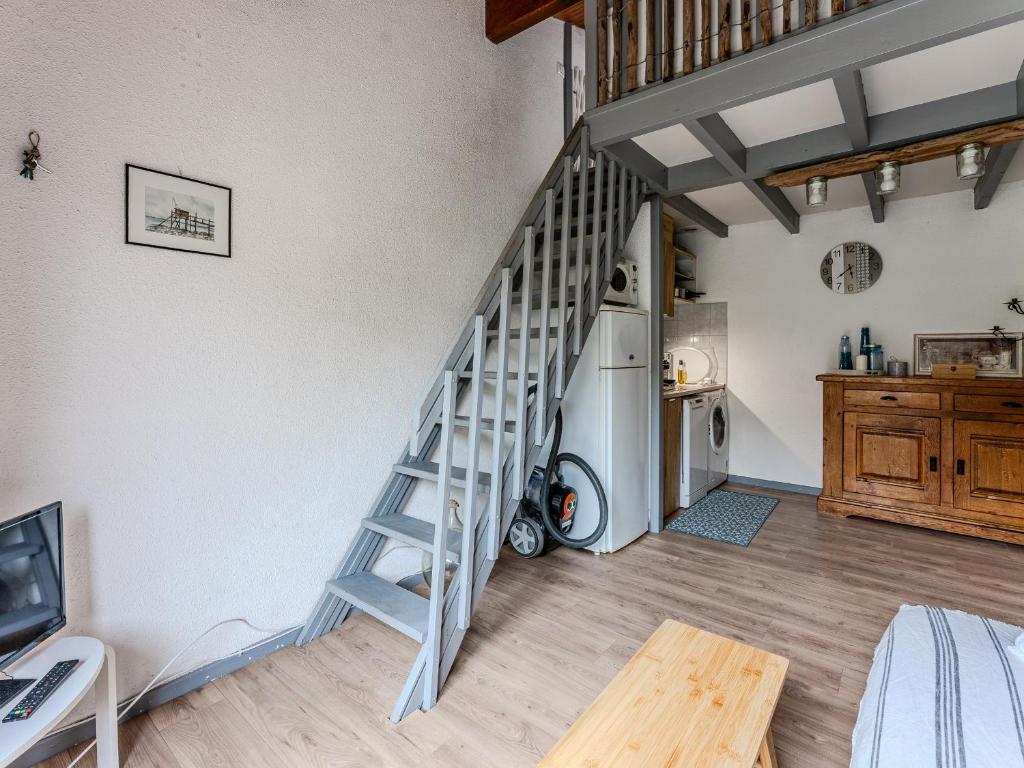 un salon avec un escalier et une cuisine dans l'établissement Maison mitoyenne 300m de la plage avec cour et parking - 4 pers, Non Fumeur - FR-1-521-242, à Biscarrosse