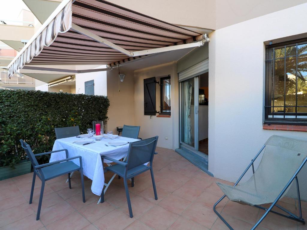d'une terrasse avec une table et des chaises sous un auvent. dans l'établissement Appartement RDC avec Terrasse, Piscine & Accès Plage - St Cyprien, 4 Couchages - FR-1-753-27, à Saint-Cyprien