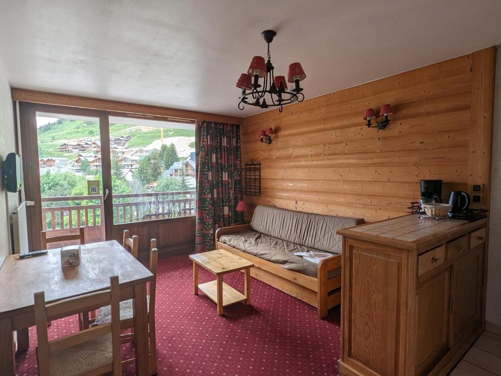 un salon avec un canapé et une table dans l'établissement Studio au pied des pistes, animaux admis - FR-1-811-7, à Les Deux Alpes