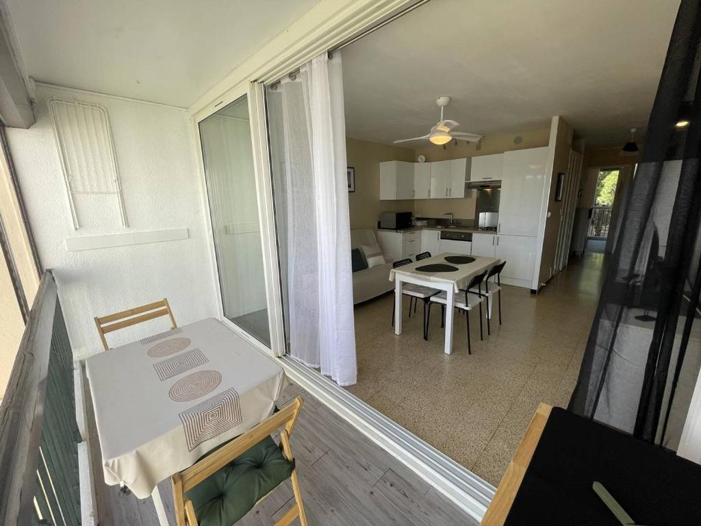 une cuisine et un salon avec une table et des chaises dans l'établissement Charmant T2 rénové, 4 couchages, proche plage et port, balcon, parking sécurisé, St-Cyprien - FR-1-106-55, à Saint-Cyprien