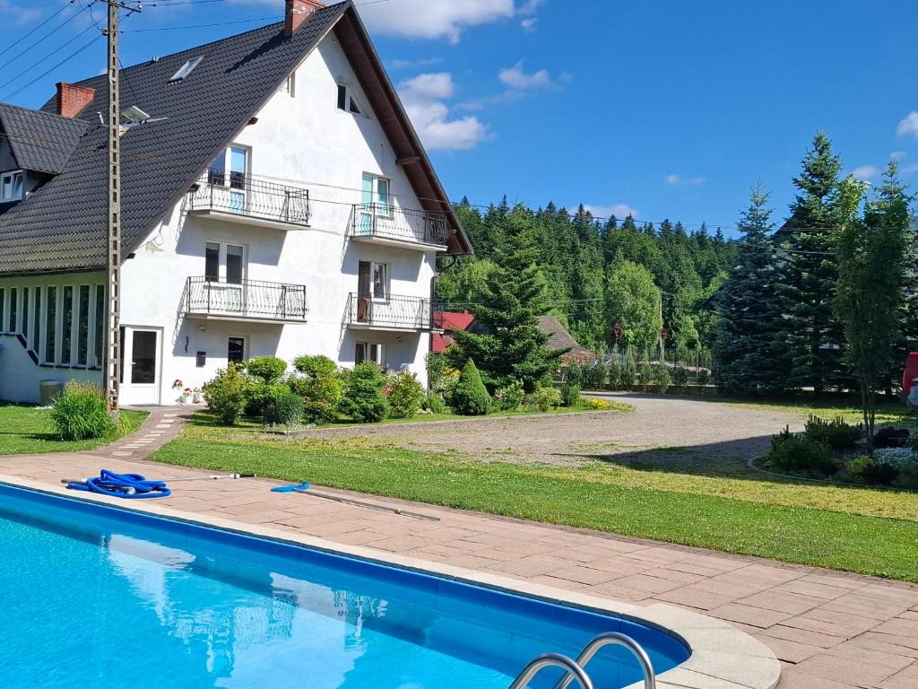 a swimming pool in front of a house at Noclegi pod Brzegiem in Zawoja