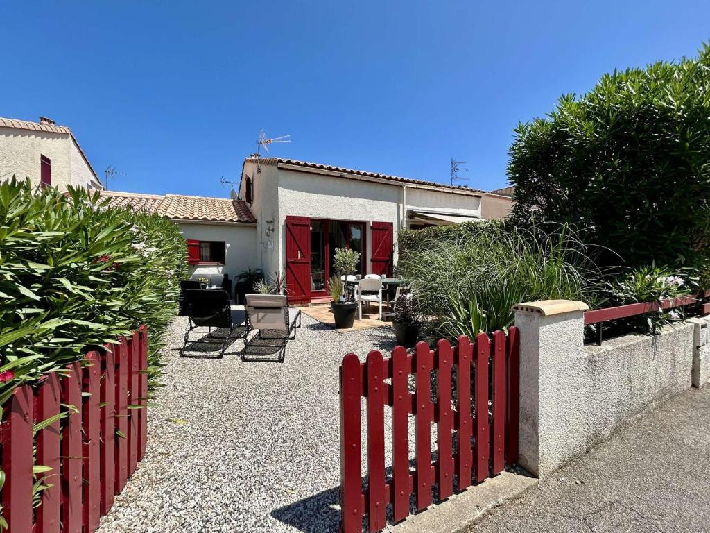 une clôture rouge devant une maison dans l'établissement Maison 3 pièces près de la plage avec climatisation et parking - Saint Cyprien - FR-1-225D-222, à Saint-Cyprien