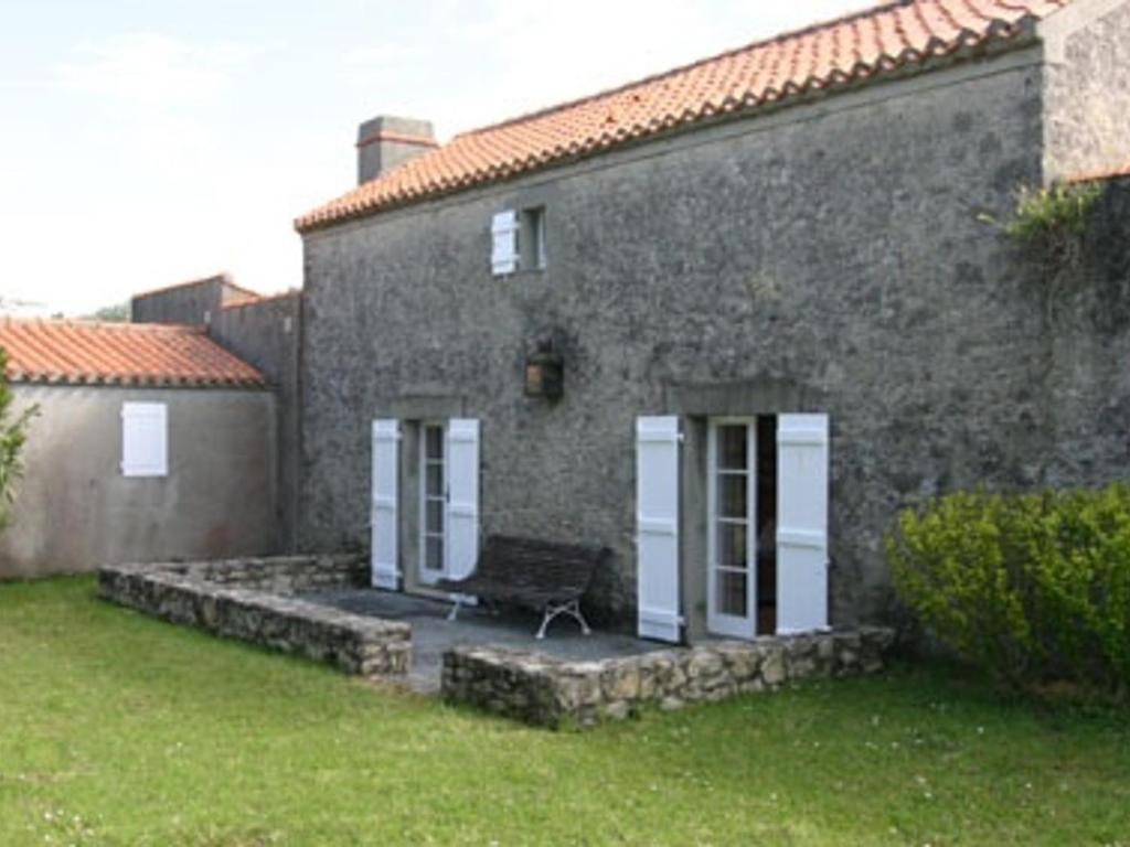 une maison en pierre avec un banc devant elle dans l'établissement Maison rénovée avec jardin, près de la plage - 5 pers, parking - FR-1-823-48, à La Guérinière