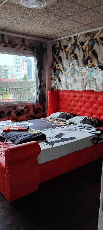 un letto con testiera rossa in una stanza di W District hostel a Bangkok
