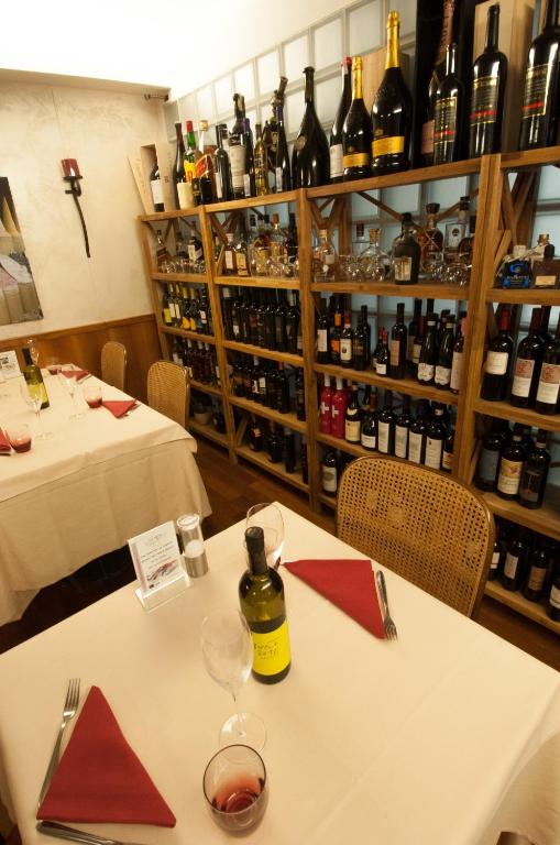 a table with a bottle of wine on top of it at Hotel Bahnhof Haus in Chiasso