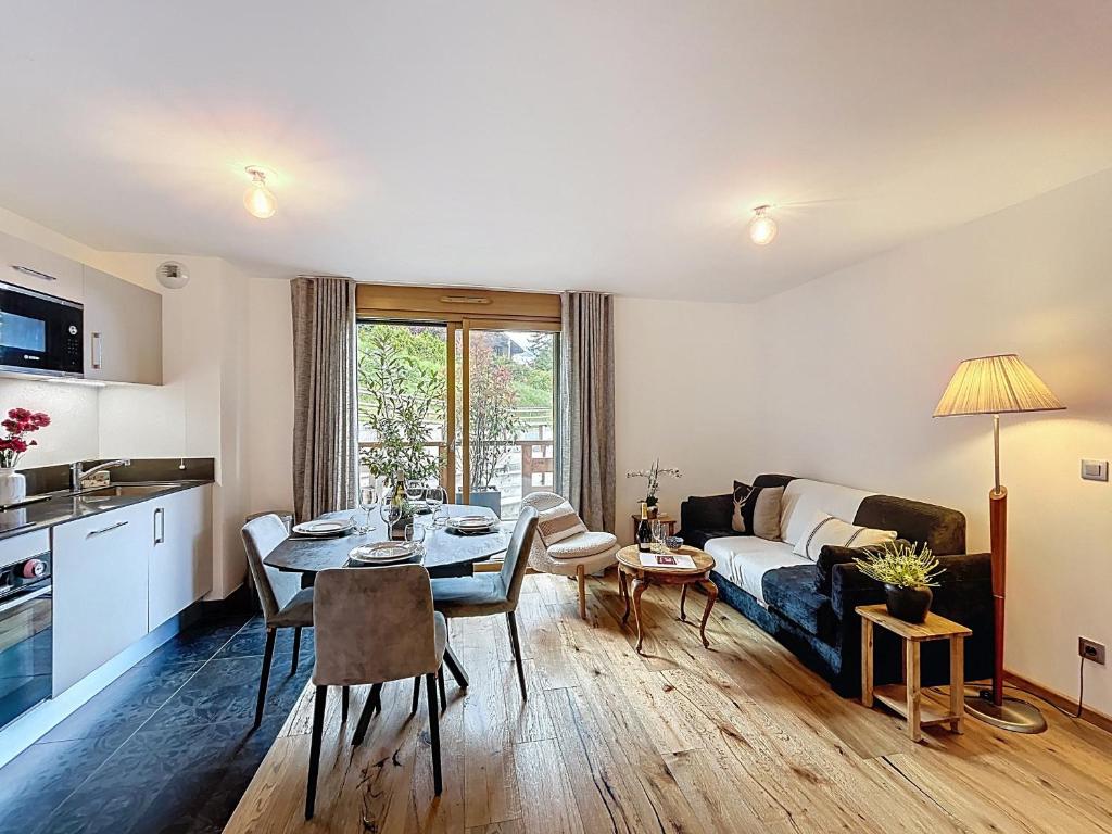- un salon avec un canapé et une table à manger dans l'établissement Bel appartement neuf proche du domaine skiable avec parking - FR-1-560-160, à Combloux