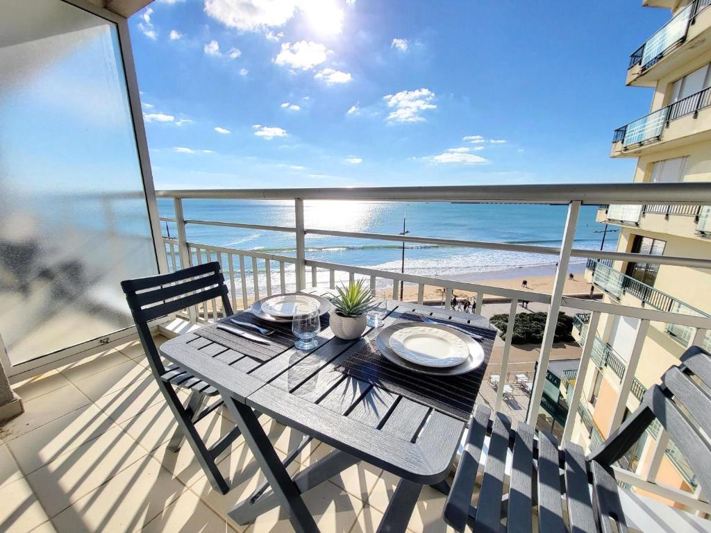 - une table sur un balcon avec vue sur l'océan dans l'établissement Studio rénové face à la plage avec balcon et garage - FR-1-92-948, à Les Sables-dʼOlonne