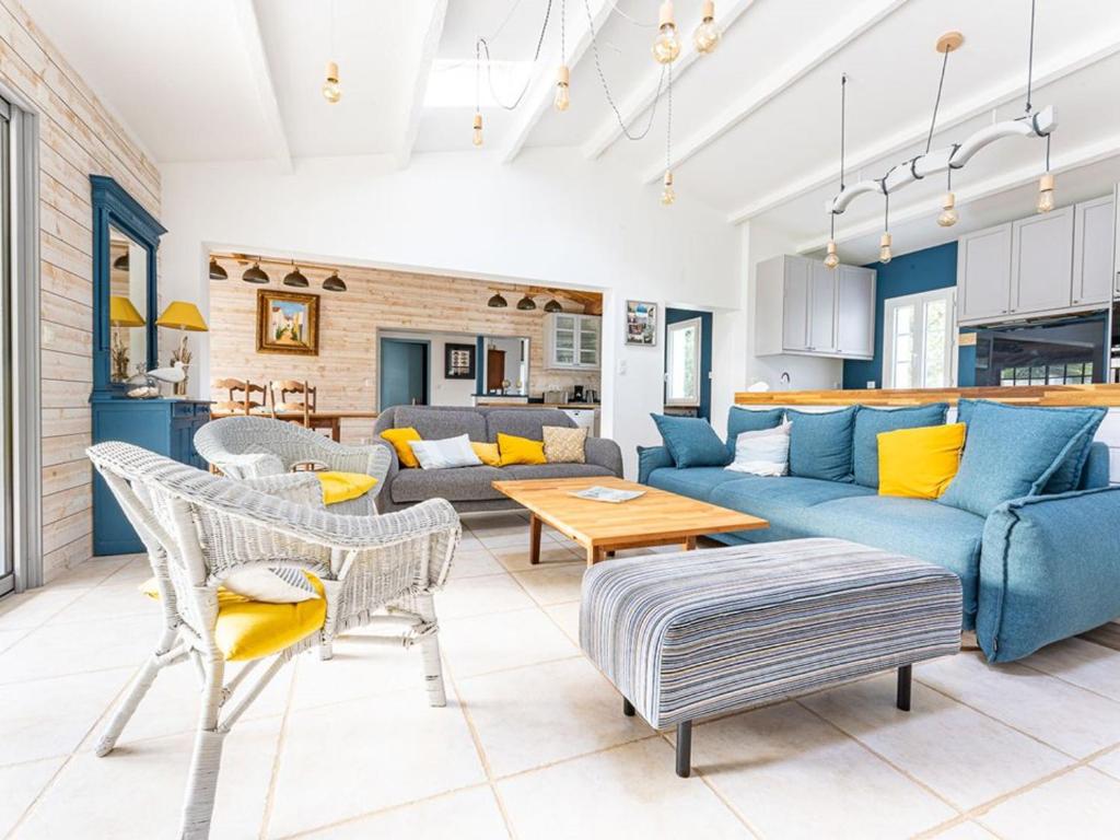 a living room with a blue couch and chairs at Maison spacieuse près de la plage pour 10 personnes - FR-1-835-2 in La Couarde-sur-Mer