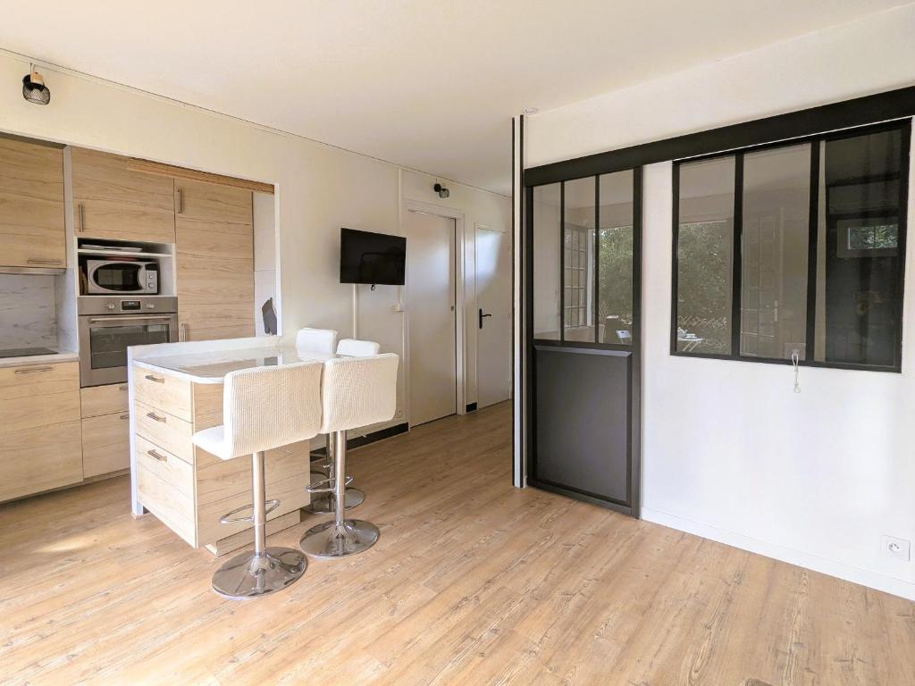 une cuisine avec un comptoir blanc et une table dans l'établissement Studio Charmant Proche Plage pour 2 Pers avec Parking - FR-1-420-159, à Arcachon