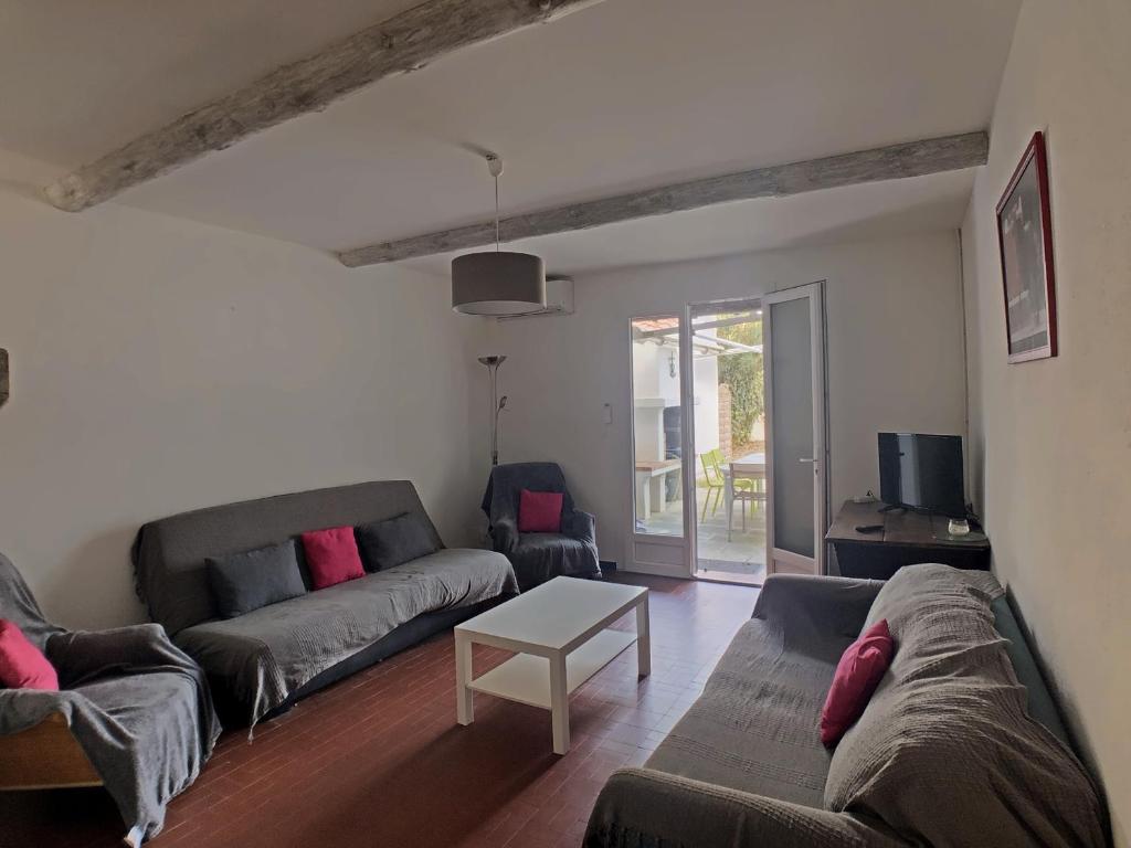 a living room with two couches and a table at Maison pour 10 pers. à 300m de la mer, Saintes-Maries-de-la-Mer - FR-1-475-202 in Saintes-Maries-de-la-Mer