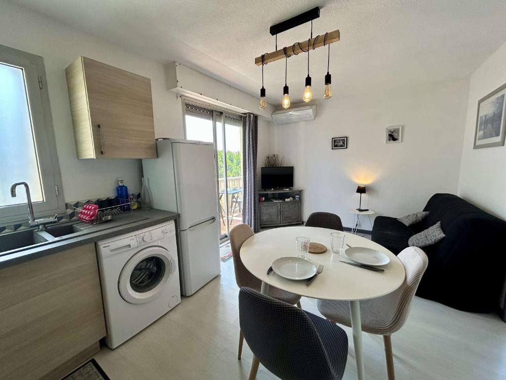 une cuisine et un salon avec une table avec des chaises et une cuisine dans l'établissement Appartement 2 pièces, climatisé, proche plage et parking à Saint Cyprien - FR-1-225D-226, à Saint-Cyprien