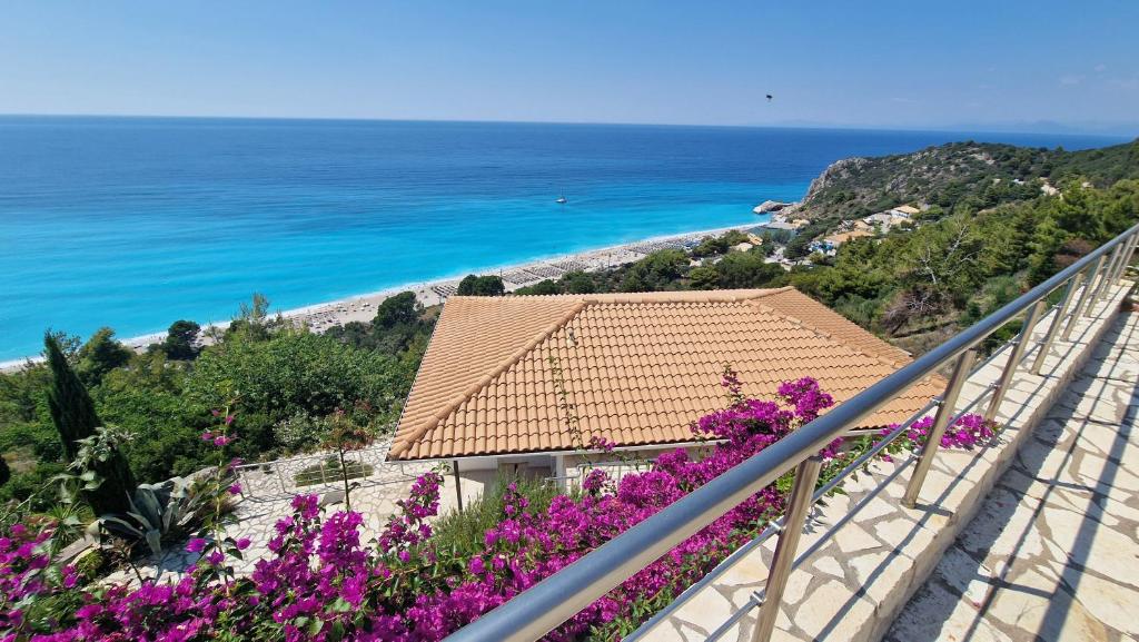 a view of the ocean from a balcony with purple flowers at Bubbles Villa Kathisma Beach View Lefkada in Agios Nikitas