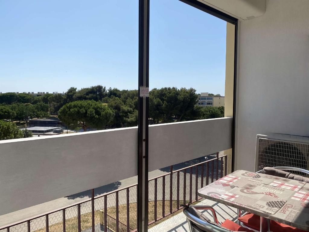 - un balcon avec une table et une vue dans l'établissement Studio vue parc avec climatisation - FR-1-553-305, à Balaruc-les-Bains