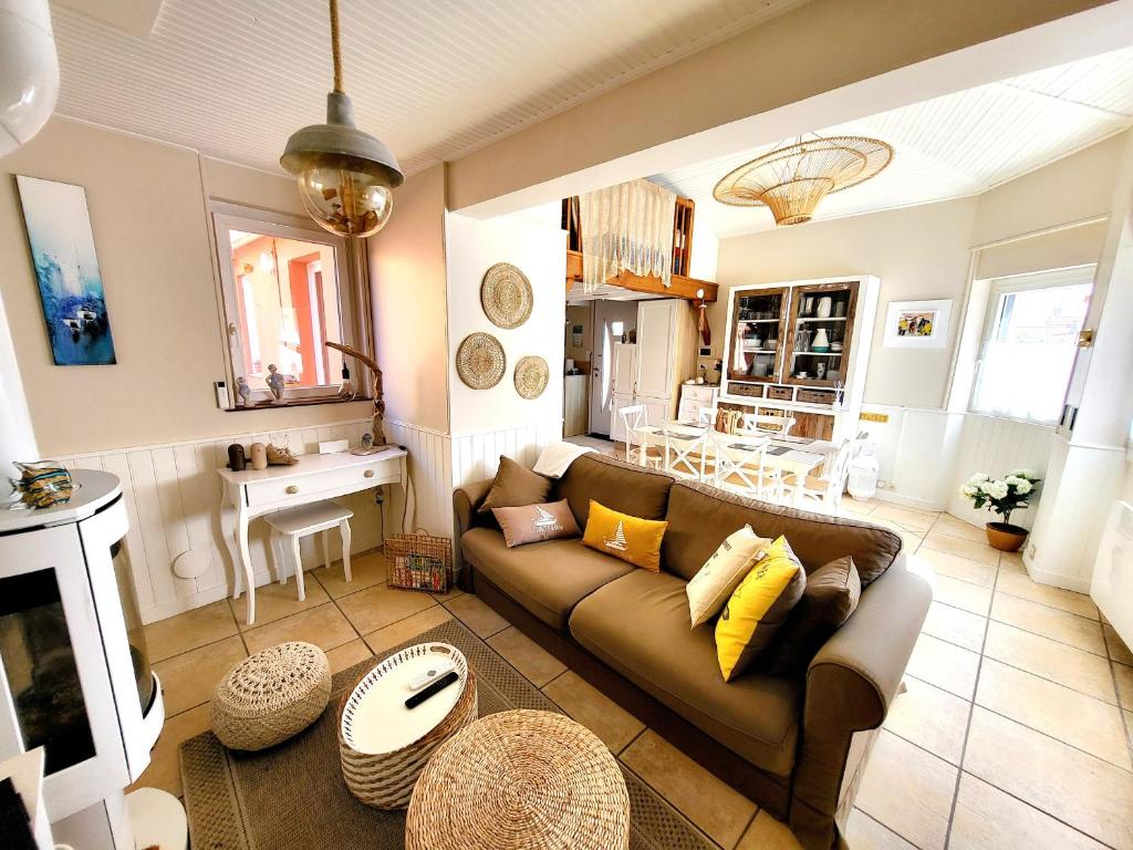 un salon avec un canapé et une table dans l'établissement Maison de pêcheur moderne avec terrasse, proche mer et commerce - Barbecue - WIFI Gratuit - FR-1-92-950, à Les Sables-dʼOlonne