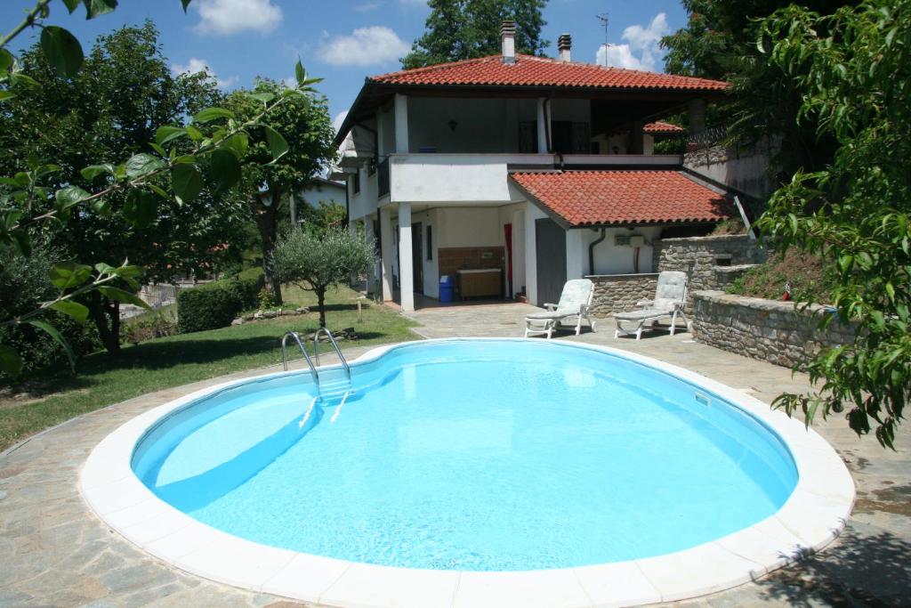 a swimming pool in front of a house at B&B Maggiora 131 in Acqui Terme