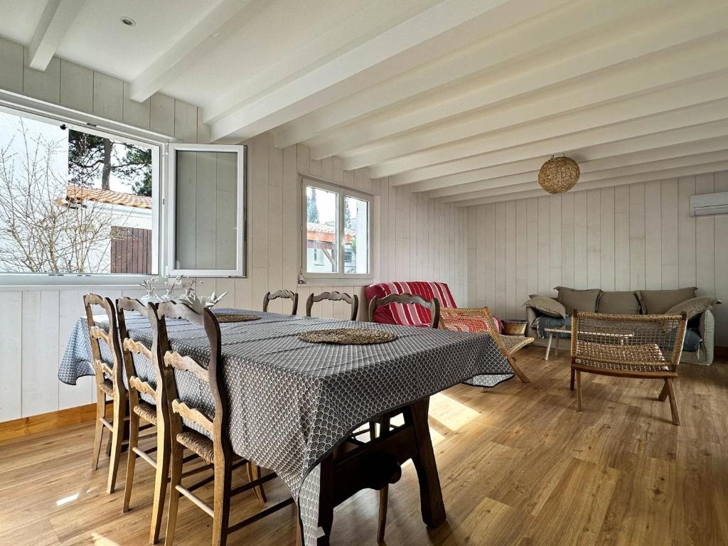 une salle à manger avec une table et des chaises dans l'établissement Villa à La Palmyre pour 7 pers, animaux admis, parking, clim, WiFi - FR-1-705-102, aux Mathes