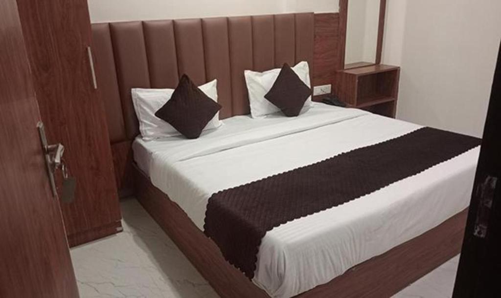 een slaapkamer met een groot bed met zwart-witte kussens bij FabHotel Shaurya Inn I - 400m from Golden temple in Amritsar
