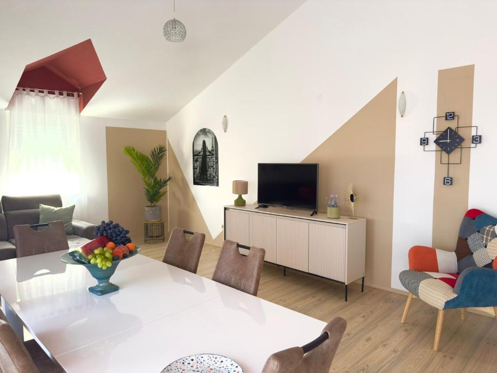 un salon avec une table blanche et une télévision dans l'établissement Apartments Dalmatino, à Kaštela