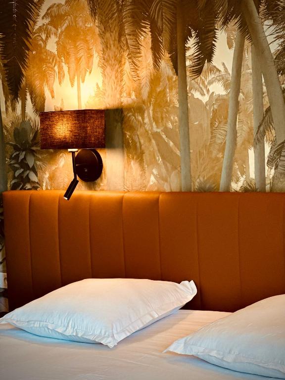 une chambre avec un lit avec une lampe et des palmiers dans l'établissement Hôtel Amaya, à Ambarès-et-Lagrave