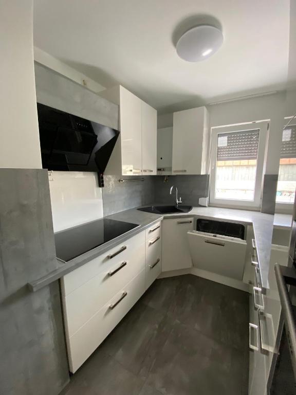 a kitchen with white cabinets and a sink at HostelCetin in Göppingen