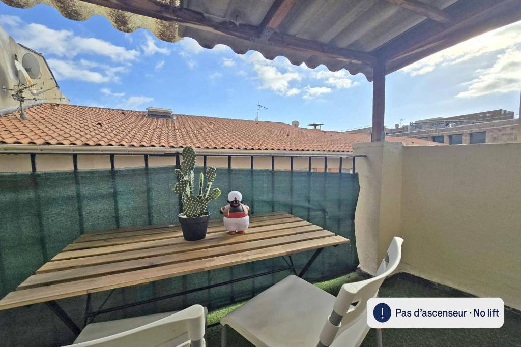 une petite table en bois sur un balcon avec un cactus dans l'établissement GregBnb - Studio RoofTop 27m2 - Terrasse 14m2 - Climatisé - 5e etage sans ascenseur, à Toulon