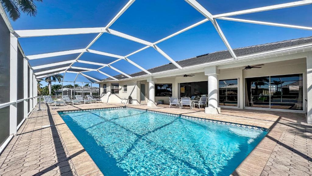 a swimming pool with a glass roof over a house at Boaters Dream S. Terr Pool Yacht Club Boating in Cape Coral