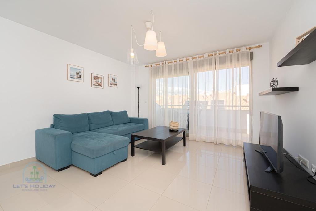 a living room with a blue couch and a tv at Beachside Attico 3 bed 2 bath in El Campello