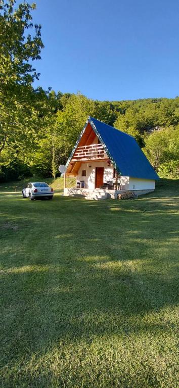 a barn with a car parked in front of it at Vikendica Izvor in Podgorica