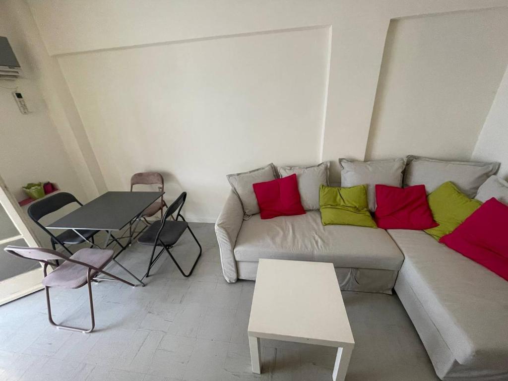 a living room with a couch with colorful pillows at Loutraki, Poseidonos seaside Apartments in Loutraki