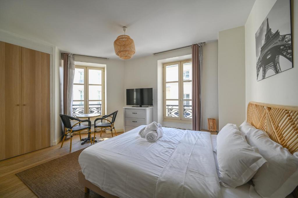 une chambre avec un lit, une table et des chaises dans l'établissement Lovely parisien apartment (opera 3), à Paris