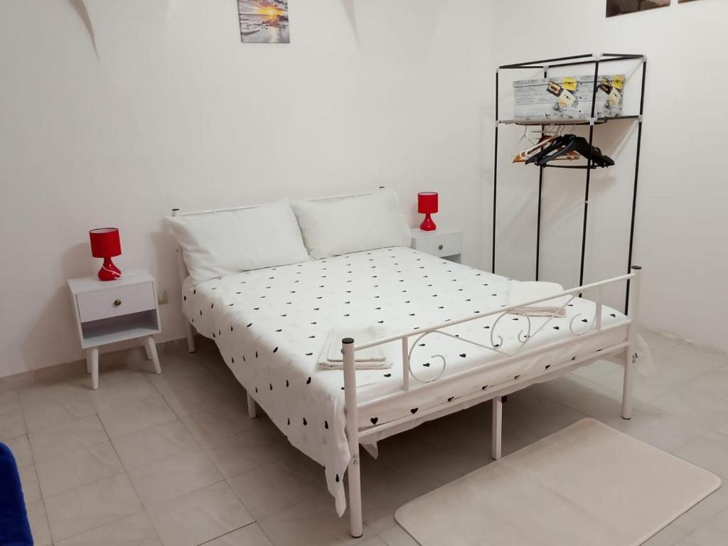 a white bed in a white room with two night stands at Domus 34 in Sassari