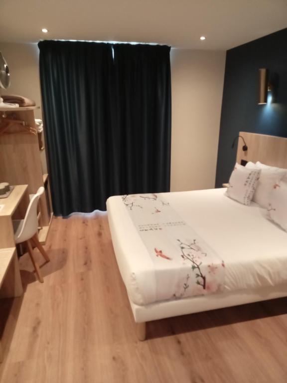 a bedroom with a white bed and a black curtain at Hotel Modern Est in Paris