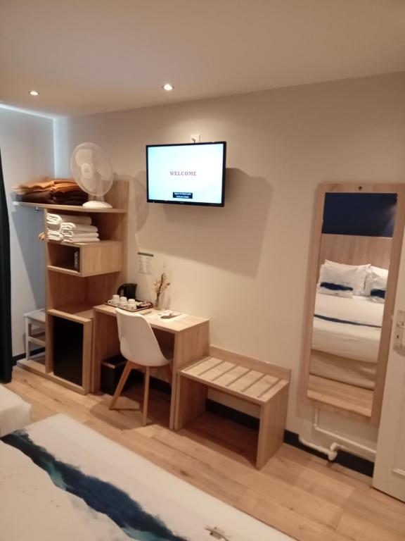 a room with a desk and a television on the wall at Hotel Modern Est in Paris