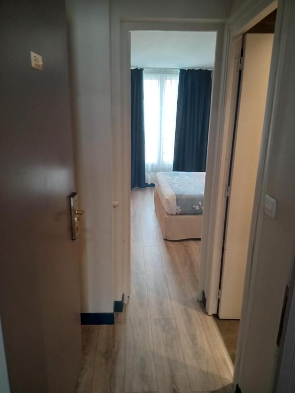 a room with a bed and a door with a window at Hotel Modern Est in Paris