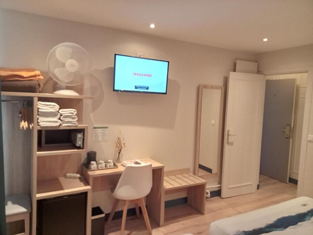 a room with a desk and a television on the wall at Hotel Modern Est in Paris