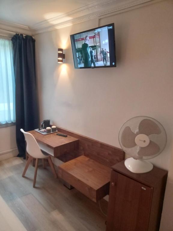 a room with a desk and a tv on the wall at Hotel Modern Est in Paris