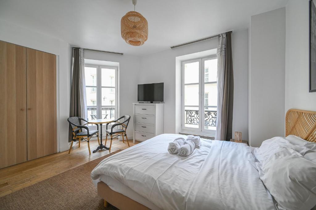 une chambre avec un lit et une table avec des chaises dans l'établissement Opéra 2, à Paris